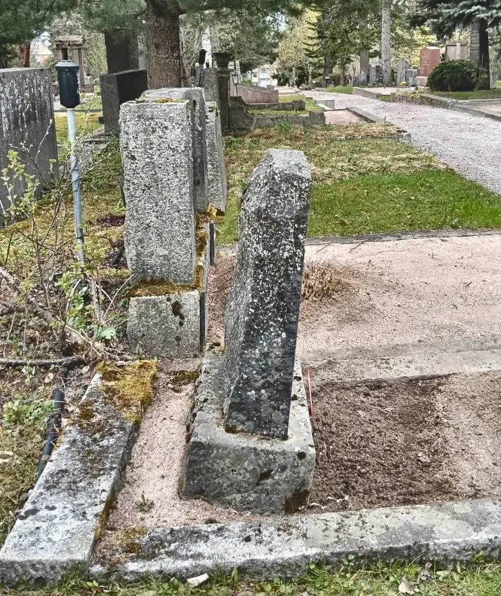 Ennen: kallistunut vanha hautakivi sivulta katsottuna